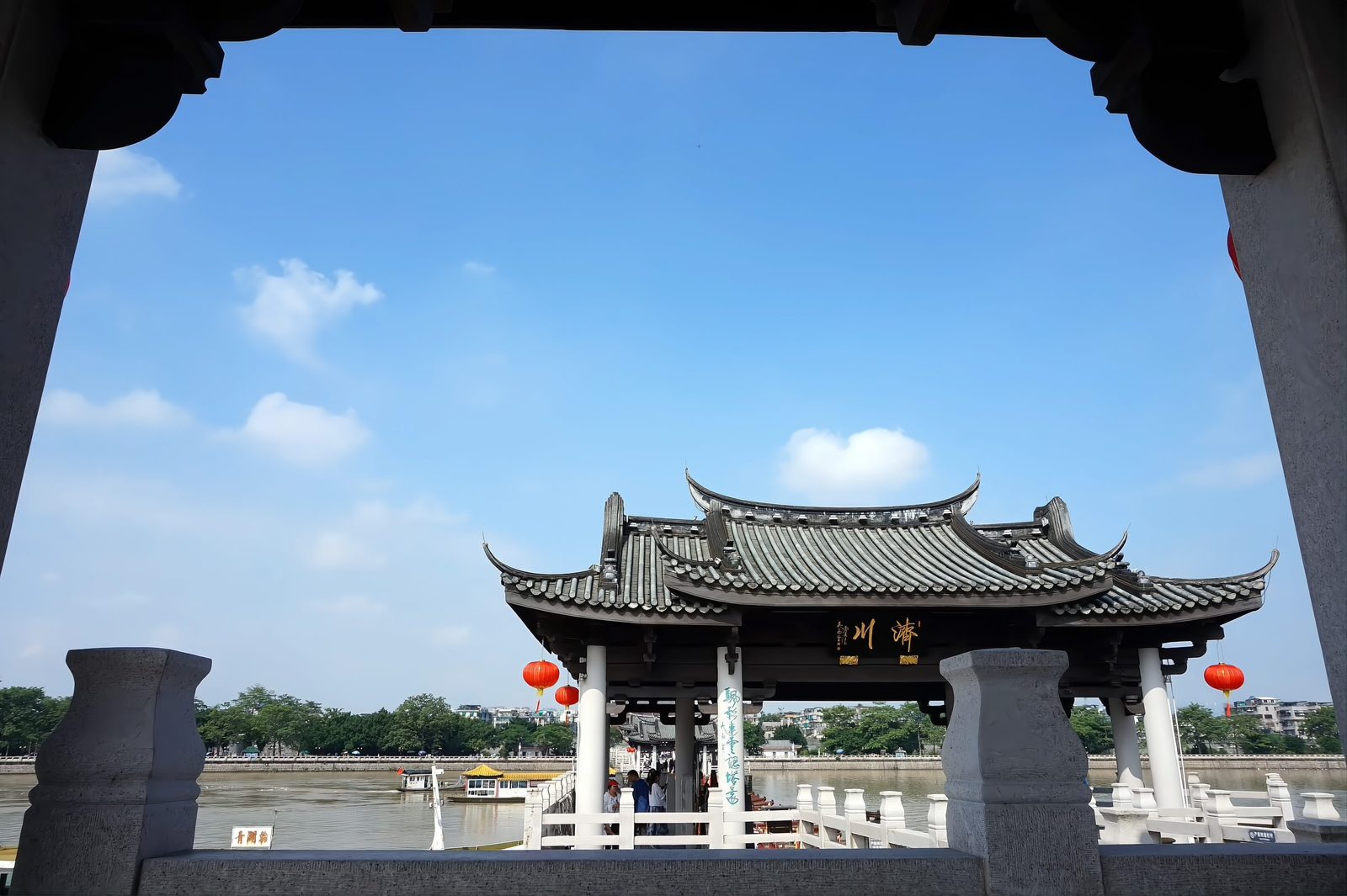 A tiled pavilion on Guangji Bridge framed against a deep blue sky