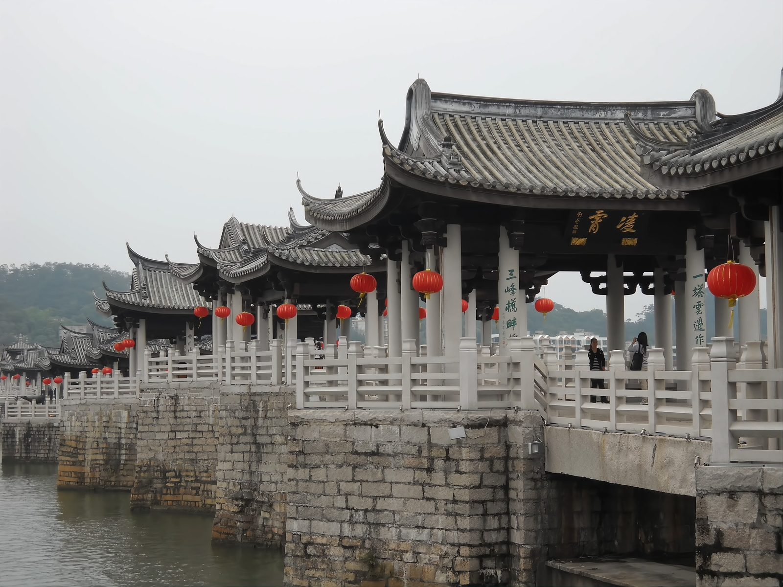 The roofline of Guangji Bridge's pavilions with red lanterns hanging along the walkway