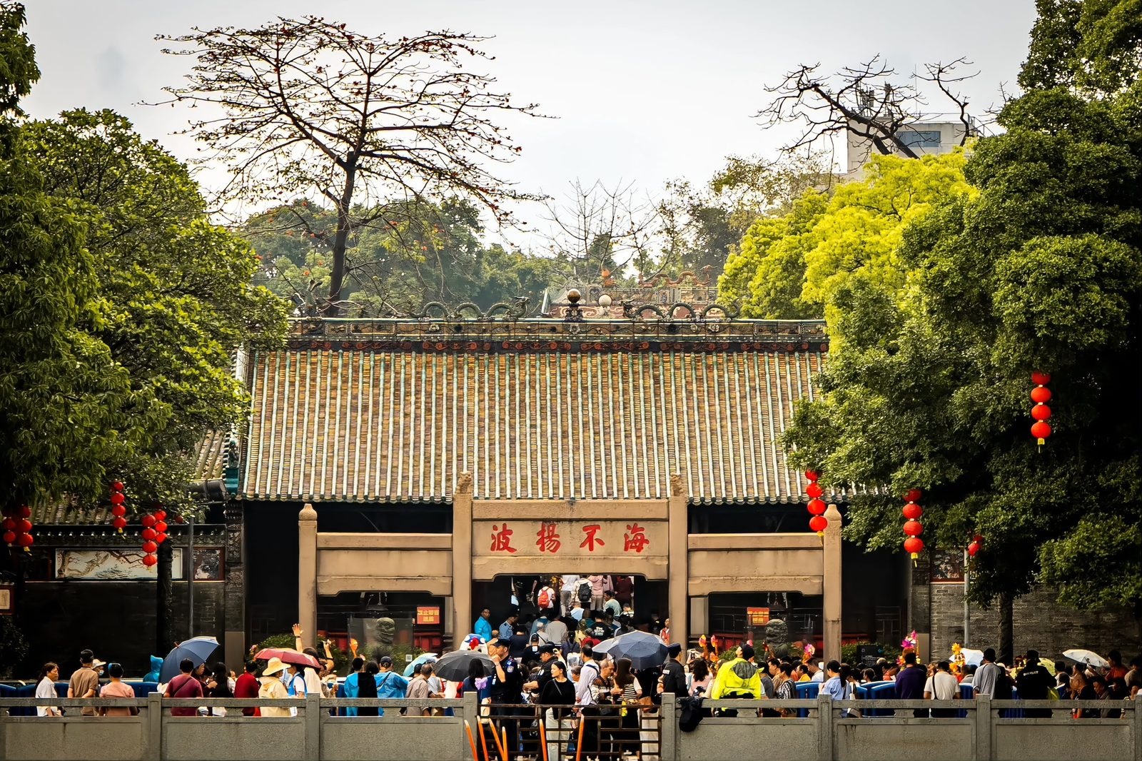 The Boluo birthday fair at Nanhai Temple: a dense crowd filling the approach to the temple under red banners and festive decorations