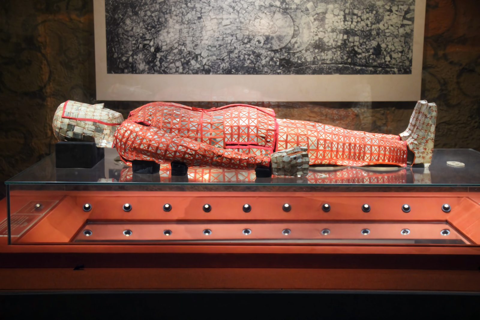 The silk-threaded jade burial suit of Zhao Mo displayed in its museum case: a full-length body covering of small jade plaques tied with red silk thread, lying flat with head covering, sleeves, gloves and shoes