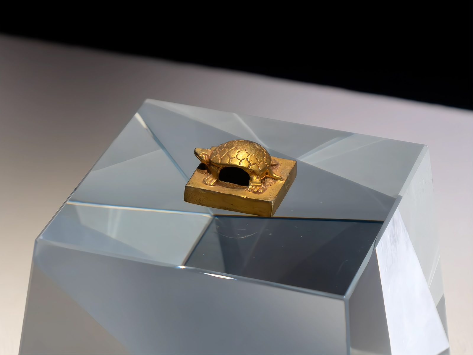 A gold seal with a tortoise-shaped knob reading Taizi, crown prince, mounted on a grey display plinth in the Nanyue King Museum