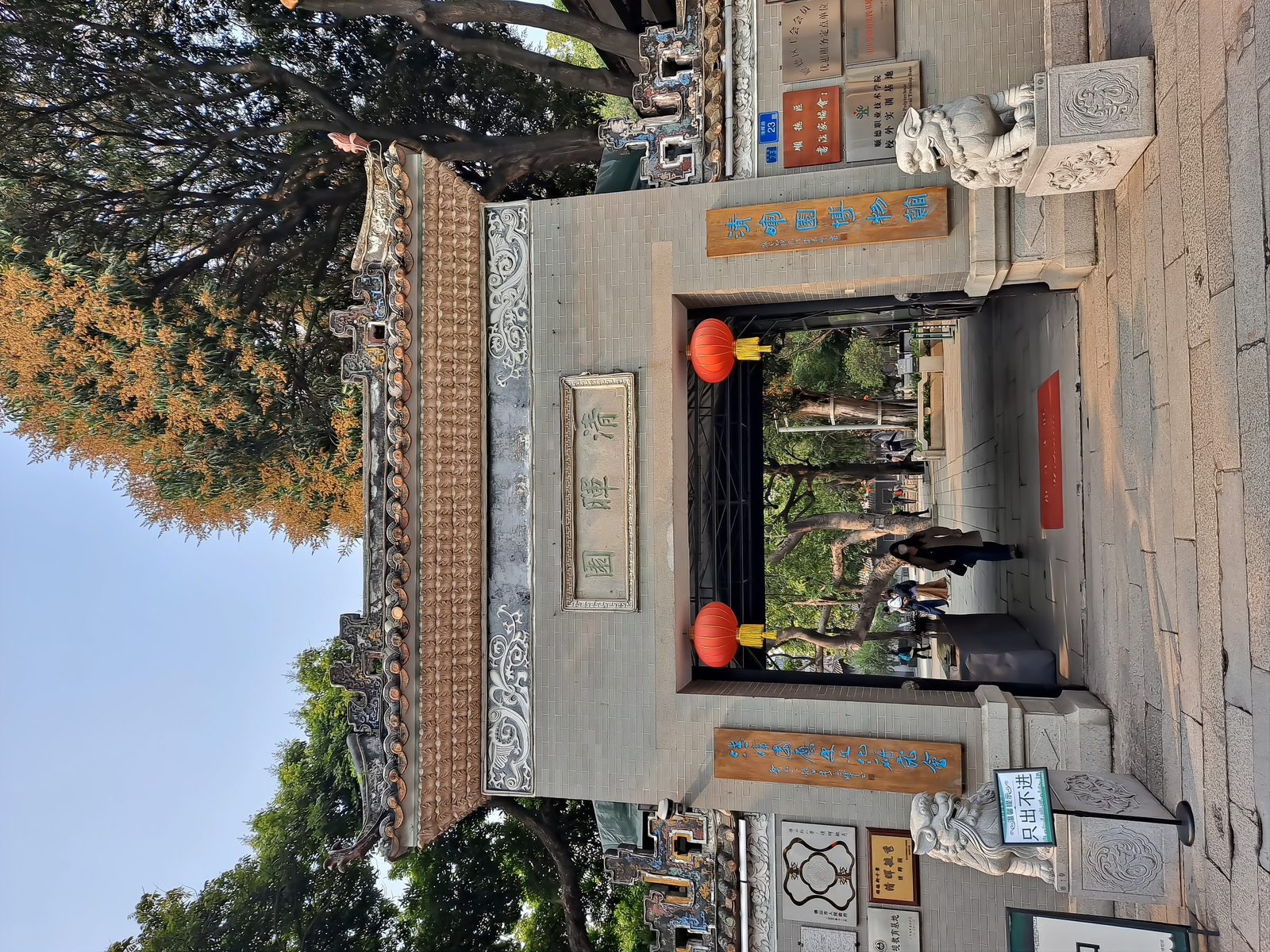 The entrance gate of Qinghui Garden: a traditional Lingnan gateway of grey brick with a plaque over the doorway, topped with a swept tiled roofline