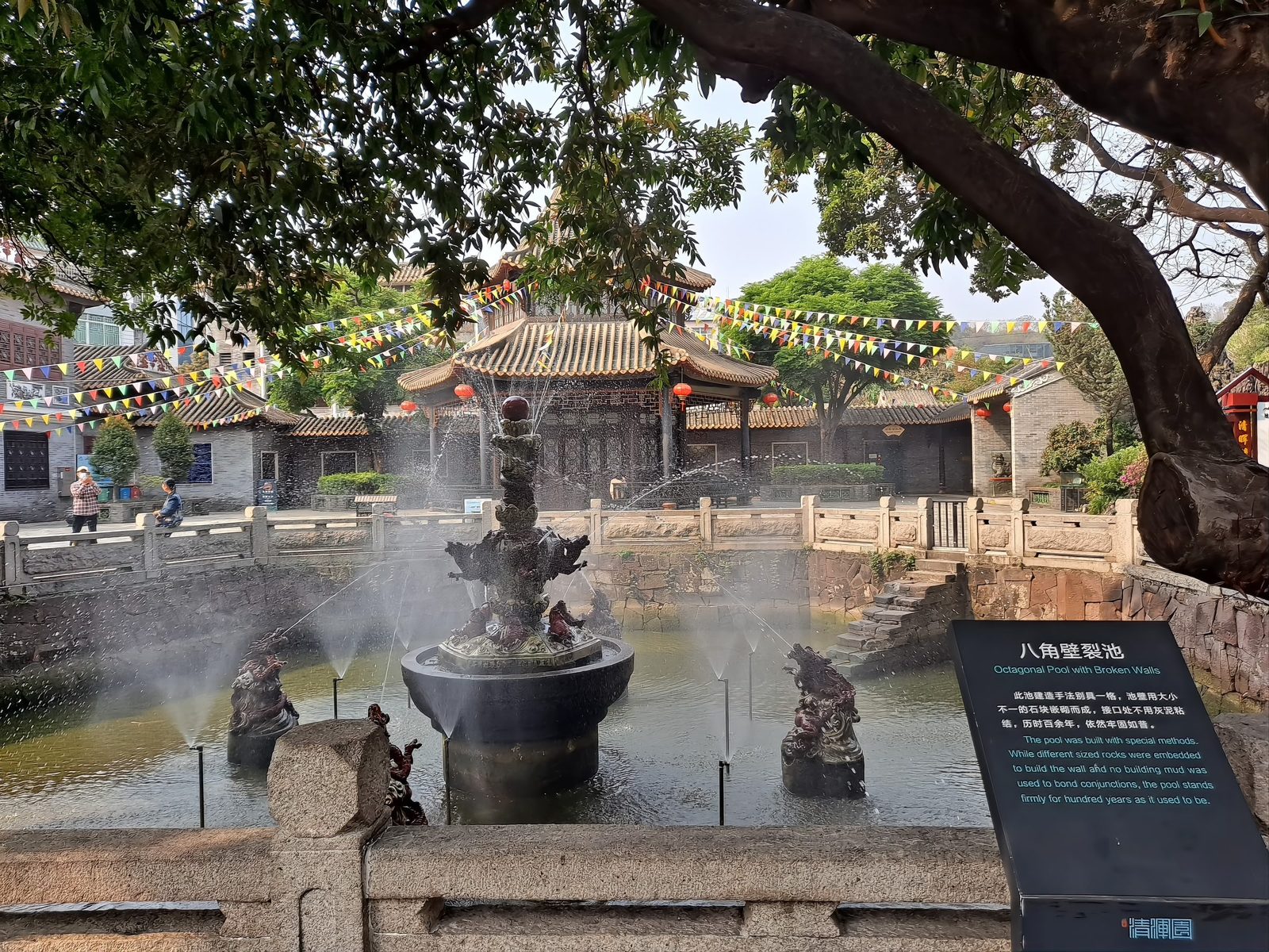 The octagonal pool just inside the garden gate: red sandstone blocks fitted together without mortar, water plants at the edges, a traditional pavilion reflected in the still water