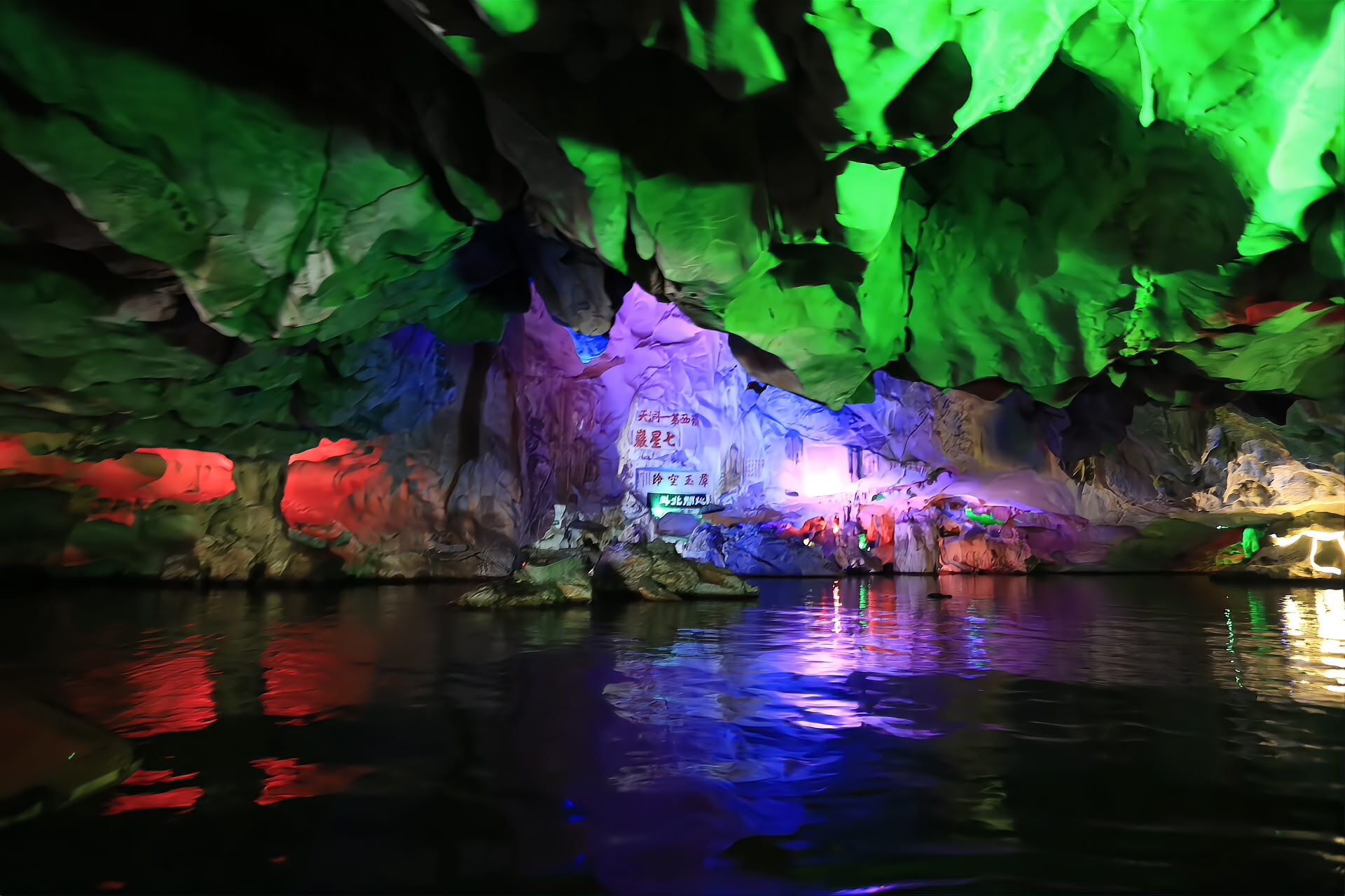 The floodlit interior of the Dragon Grotto water cave under the Seven Star Crags